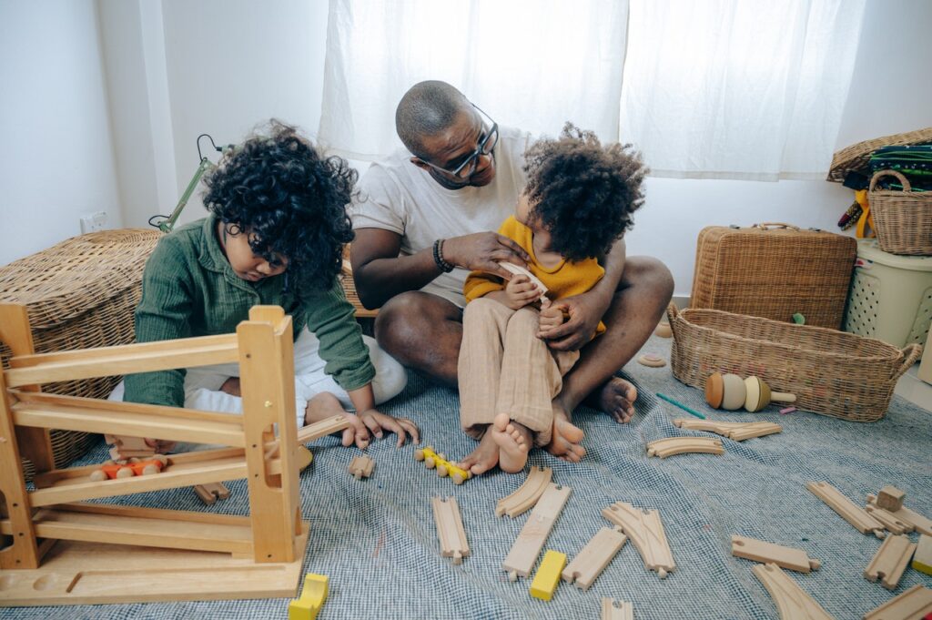 Dad playing with a train set with his children